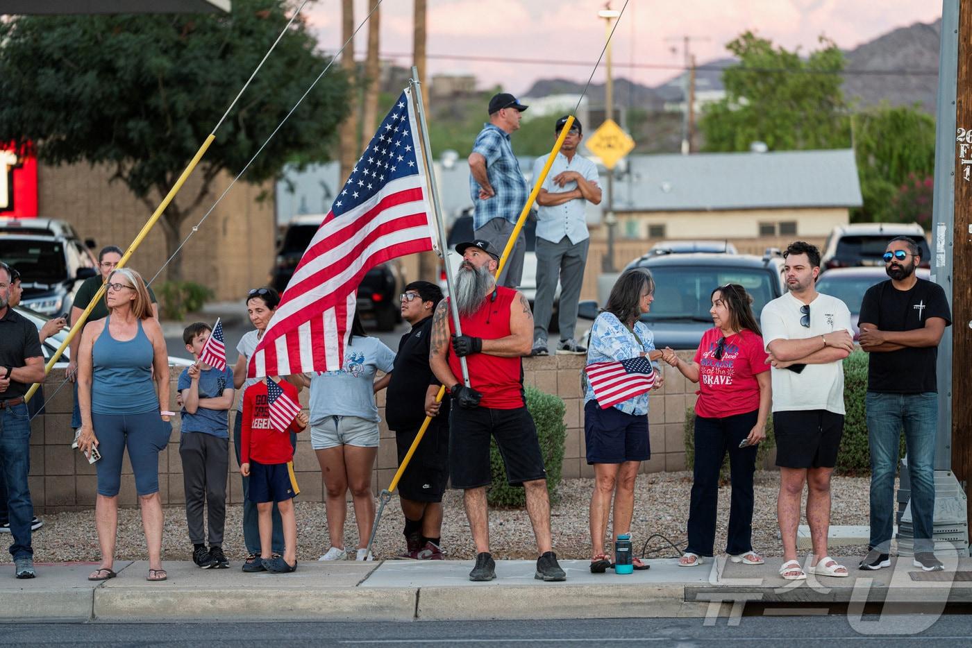 11일(현지시간) 총격으로 피살된 미국의 극우성향 논객 찰리 커크의 시신이 안치된 애리조나주 피닉스의 장례식장에 그의 지지자들이 성조기를 들고 모여 있다. 커크는 10일 유타주 유타 밸리 대학교에서 열린 공개토론 행사에서 피격됐으며 용의자는 아직 잡히지 않았다. 2025.09.11 ⓒ 로이터=뉴스1 ⓒ