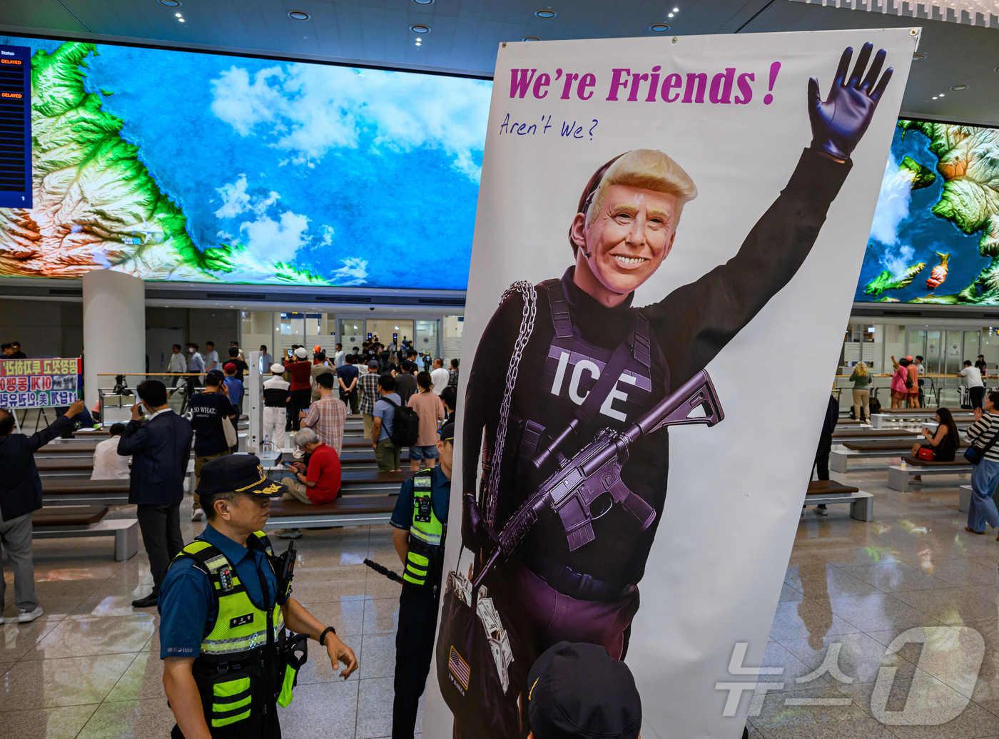 본문 이미지 - 미국 조지아주 포크스턴 이민세관단속국&#40;ICE&#41; 구금 시설에서 체포·구금됐다 풀려난 한국인 316명이 탑승한 전세기가 12일 인천국제공항 2터미널에 도착한 가운데, 이제석 이제석광고연구소 대표가 공항 입국장에서 트럼프 미국 대통령 얼굴이 담긴 플래카드 퍼포먼스를 펼치고 있다.&#40;공동취재&#41; 2025.9.12/뉴스1 ⓒ News1 박지혜 기자