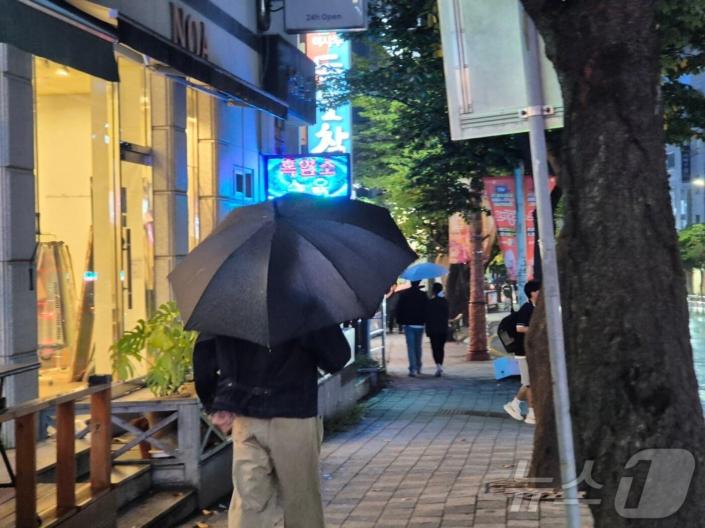 본문 이미지 - 지난 12일 오후 강원 강릉 교통 일대에서 우산을 쓴 시민들이 발걸음을 옮기고 있다. 기상청은 극심한 가뭄이 이어지는 강릉을 포함한 동해안에 오는 14일까지 30~80㎜(많은 곳 북부동해안 100㎜이상)의 비가 내릴 것으로 예보했다.2025.9.12./뉴스1 윤왕근기자 ⓒ News1 윤왕근 기자