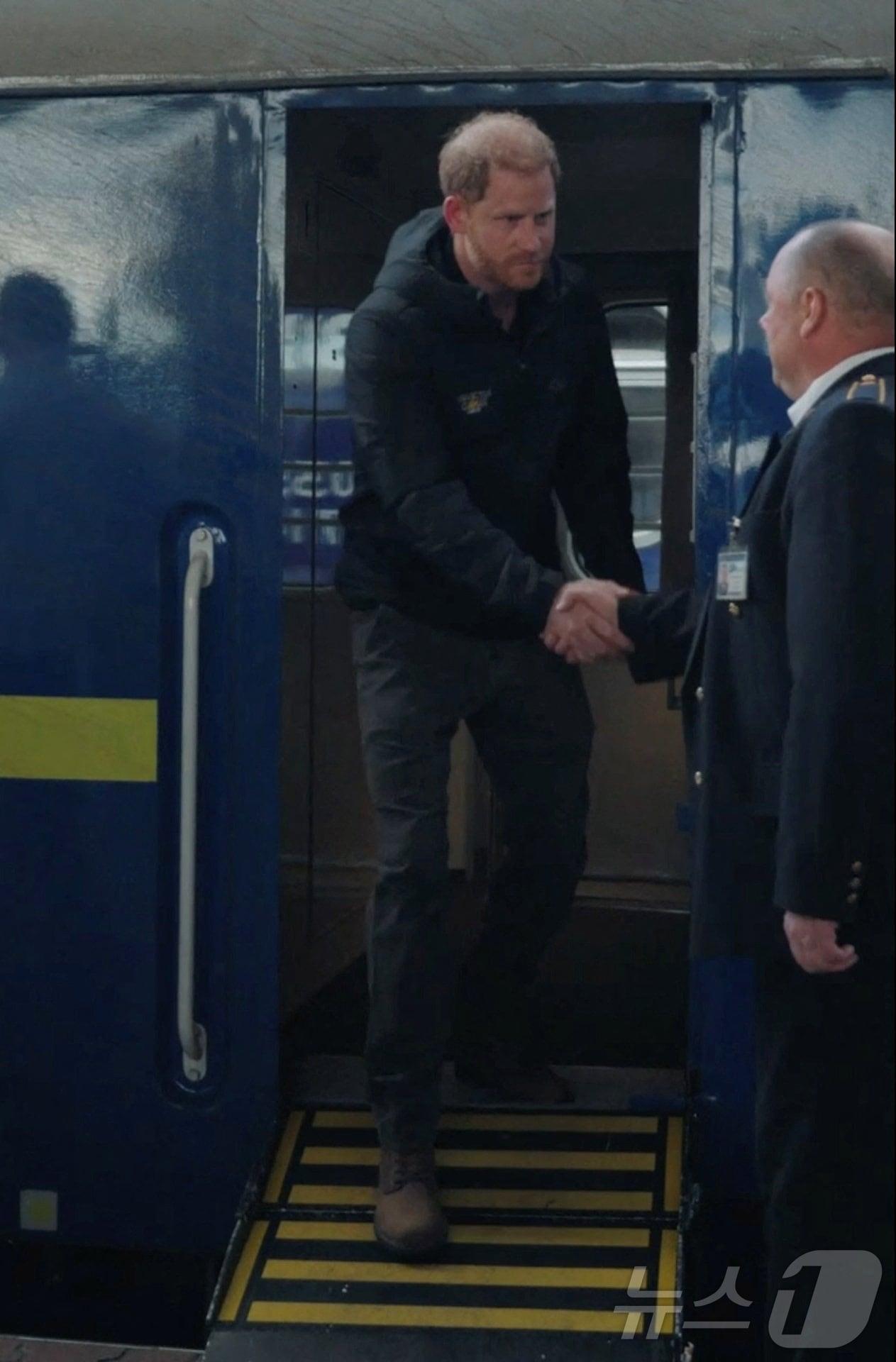 본문 이미지 - 12일&#40;현지시간&#41; 우크라이나 키이우역에 도착한 영국 해리 왕자가 열차에서 내리며 철도 직원과 악수하고 있다. 2025.9.12ⓒ 로이터=뉴스1