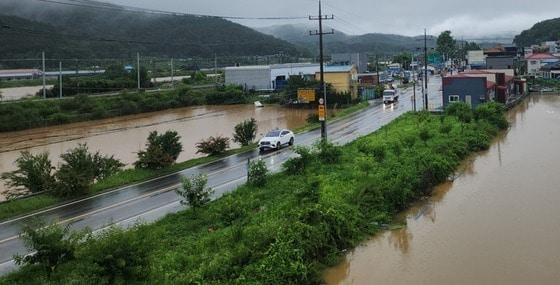 본문 이미지 - 지난 7월 17일 집중호우로 침수된 세종시 전동면 노장리 도로옆 농경지. 마치 세개의 하천이 흐르는 모습이다. 왼쪽 맨 위 물줄기가 실제 하천이다.(독자 황순덕 씨 제공. 재판매 및 DB금지)/뉴스1