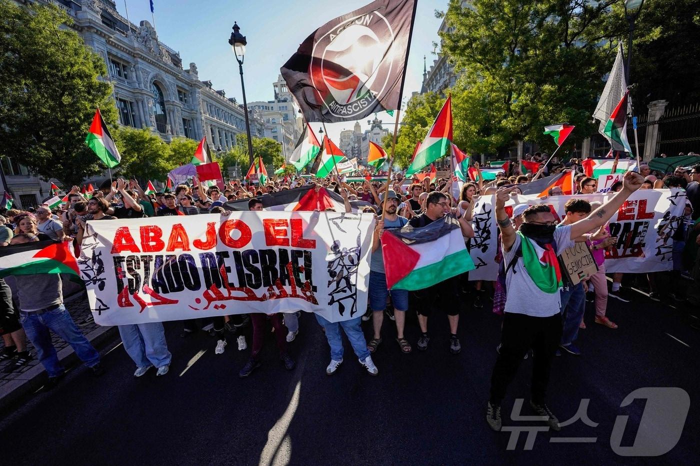 친팔레스타인 시위대가 14일(현지시간) 마드리드에서 열린 '부엘타 아 에스파냐'(Vuelta a Espana) 마지막 구간에서 팔레스타인 국기와 관련 현수막을 들고 있다. 2025.9.14 ⓒ AFP=뉴스1