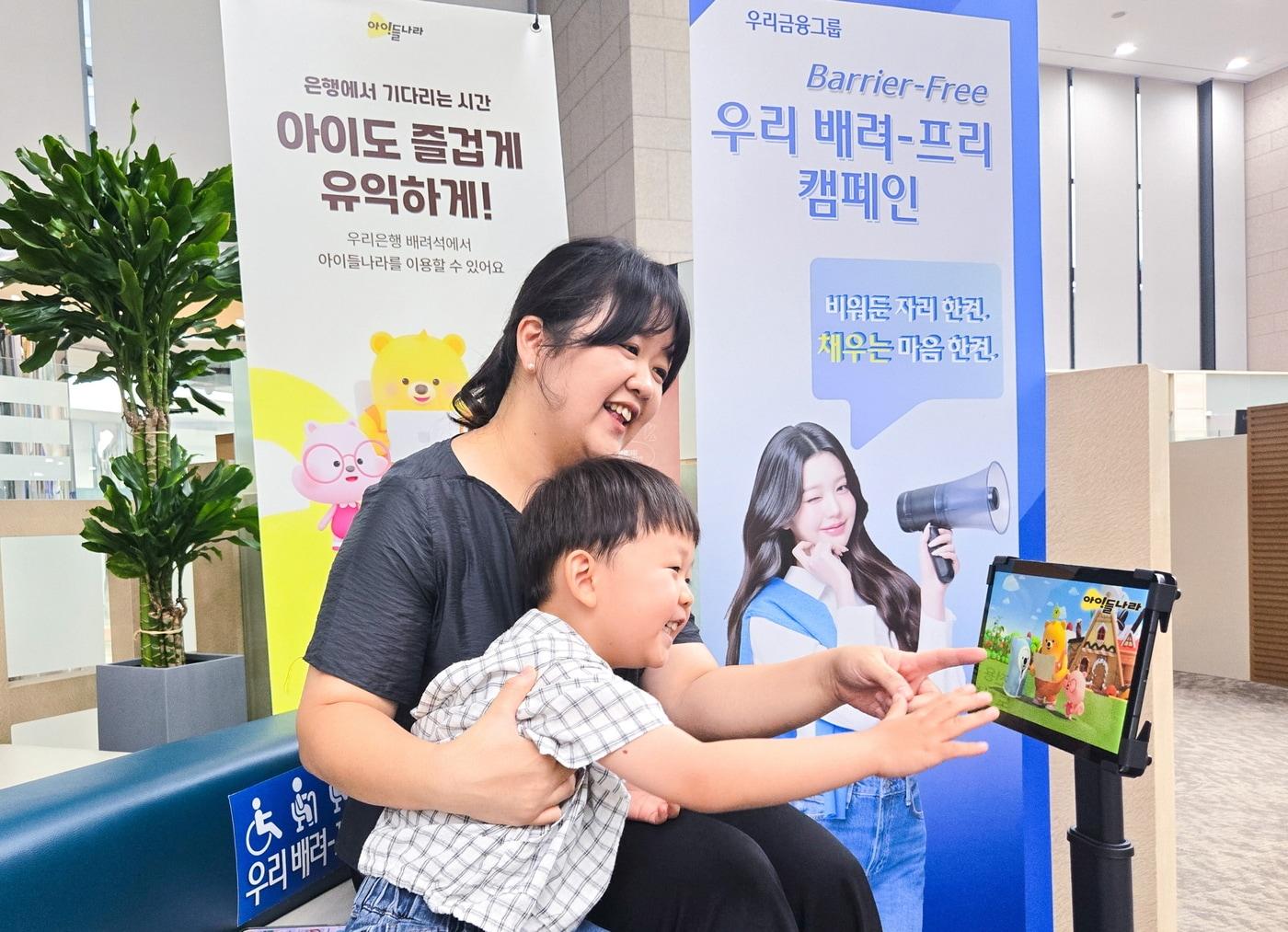 본문 이미지 - LG유플러스가 우리은행 방문하는 영유아 고객을 위해 키즈 전용 서비스 '아이들나라'를 무료로 제공한다. 사진은 영유아 모델이 우리은행 본점 배려프리석에서 아이들나라를 시청하고 있는 모습. (LGU+ 제공)