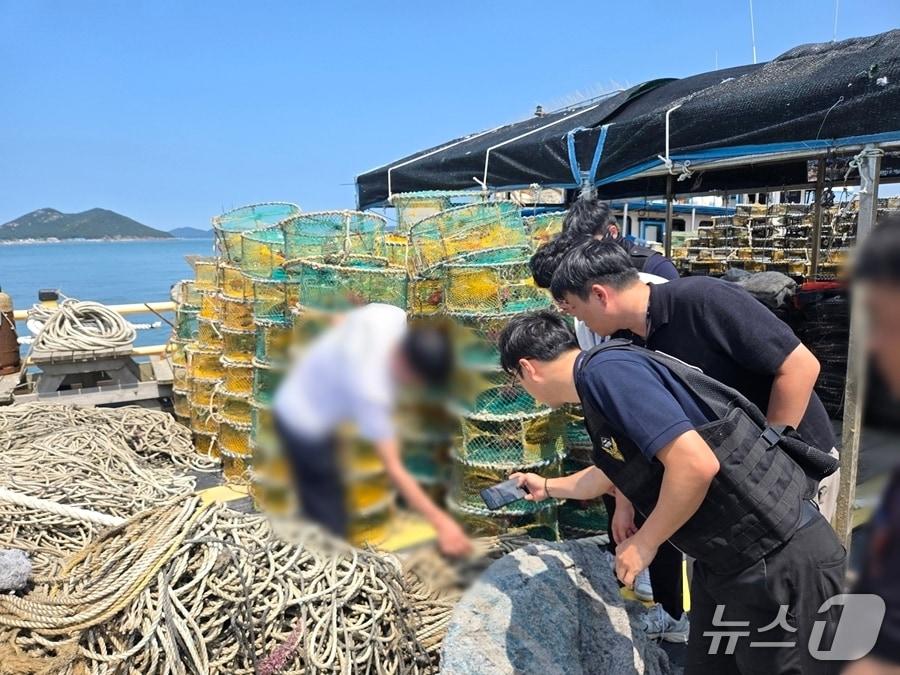 본문 이미지 - 도난 통발 그물을 확인 중인 해경.&#40;군산해경 제공. 재판매 및 DB금지&#41;
