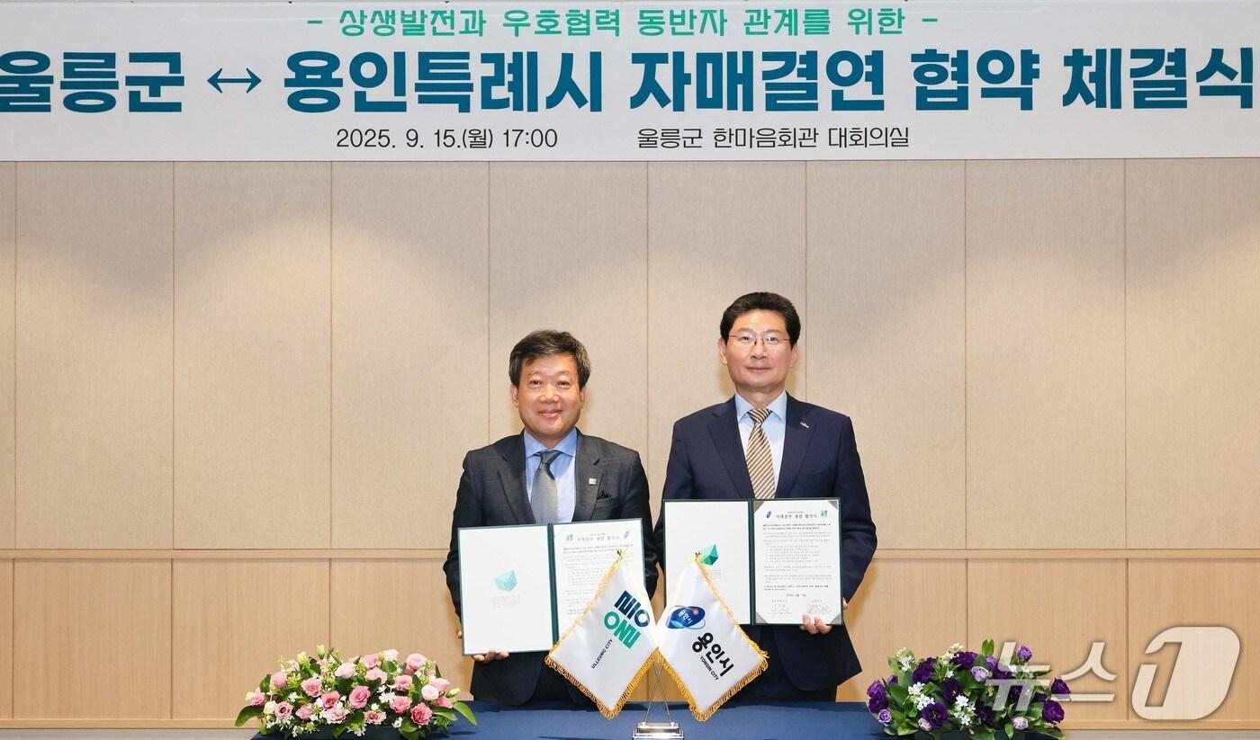 이상일 용인시장(오른쪽)과 남한권 울릉군수가 자매결연 협약서에 서명한 뒤 기념촬영을 하고 있는 모습.(용인시 제공)