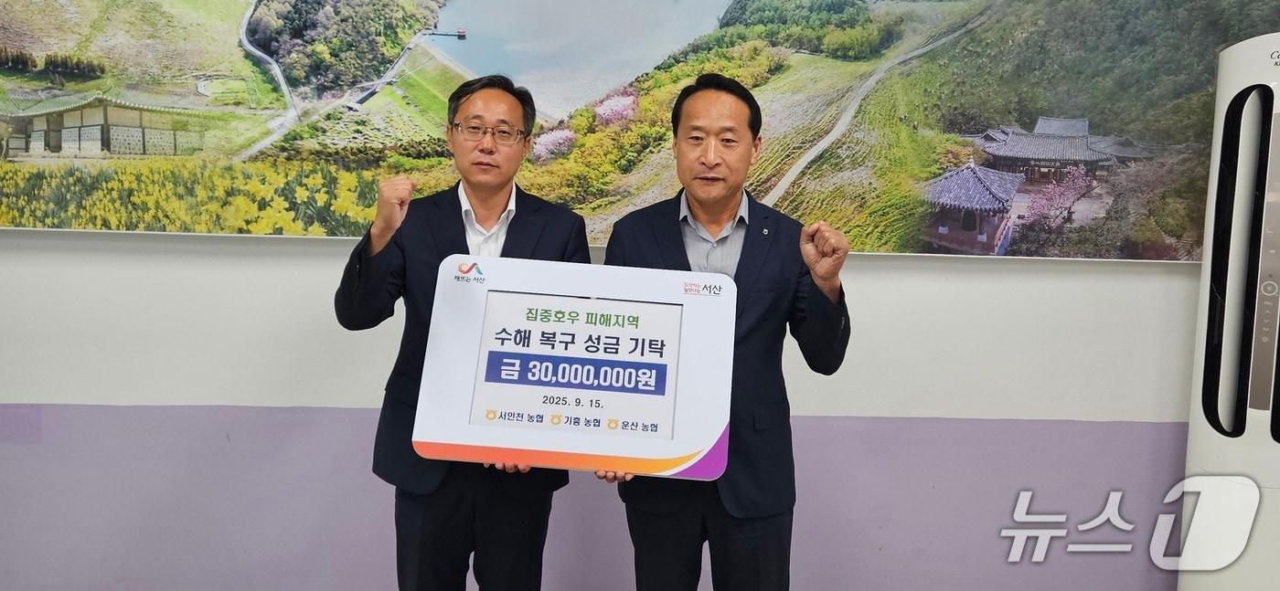 본문 이미지 - 지난 15일 운산면 행정복지센터 회의실에서 열린 전달식에서 김윤환 면장(왼쪽)이 이남호 운산농협 조합장으로부터 성금을 전달받고 기념촬영을 하고 있다.(제공. 재판매 및 DB금지)2025.9.16/뉴스1