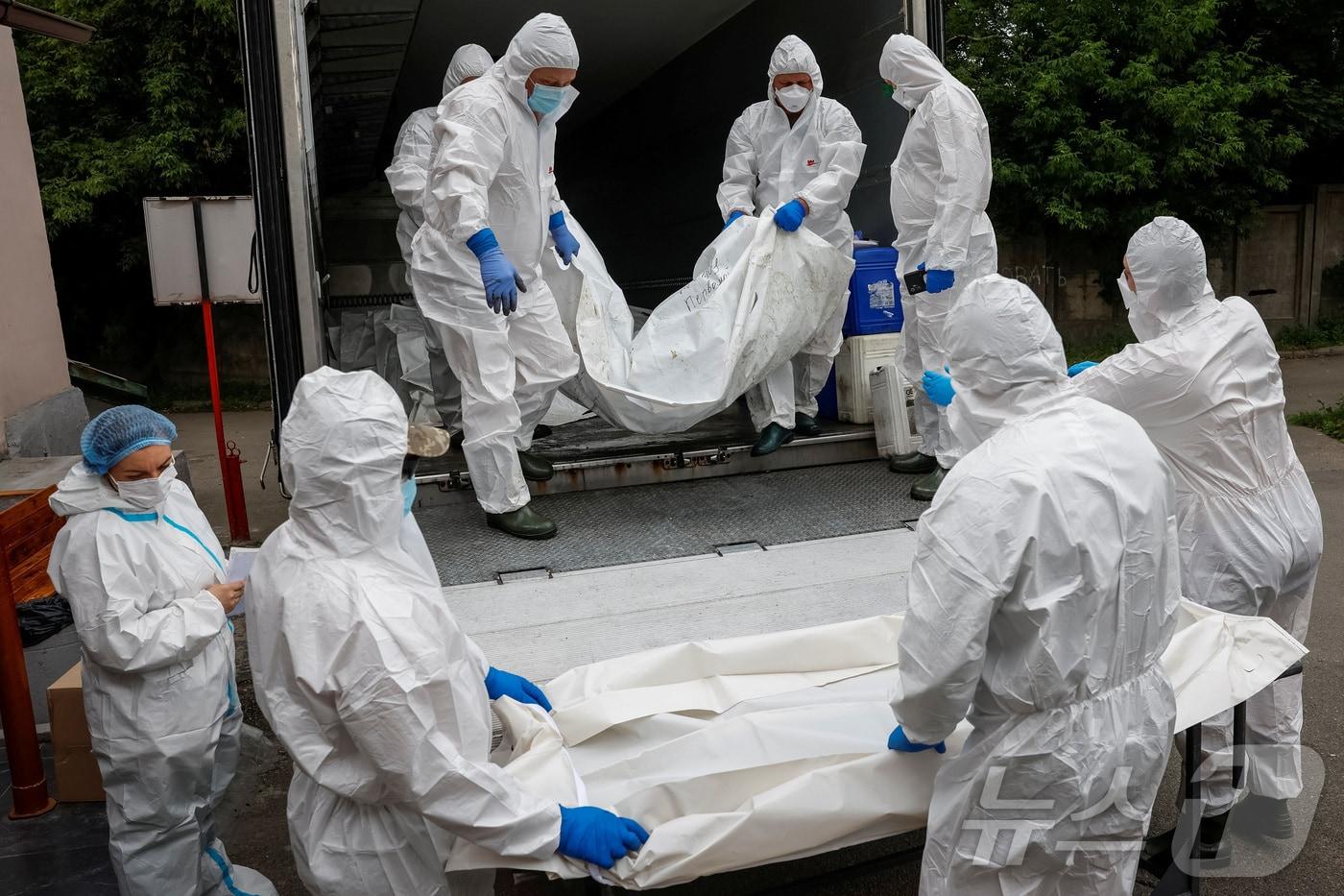 본문 이미지 - 우크라이나 정부 관계자들이 2025년 6월 26일 튀르키예 이스탄불에서 러시아와 우크라이나 간의 합의에 따라 러시아로부터 인도받은 유해를 키이우의 영안실로 옮고 있다. 2025.6.26. <자료 사진>ⓒ 로이터=뉴스1