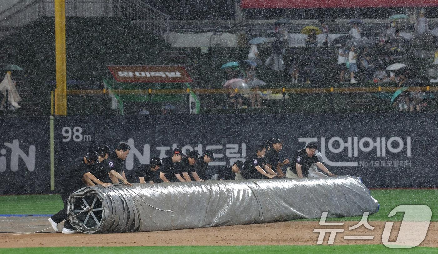 16일 오후 경기 수원시 장안구 KT위즈파크에서 열린 &#39;2025 신한 SOL 뱅크 KBO리그&#39; LG 트윈스와 KT 위즈의 경기, 3회말 우천으로 경기가 중단돼 구단 관계자가 방수포를 덮고 있다. 2025.9.16/뉴스1 ⓒ News1 김영운 기자