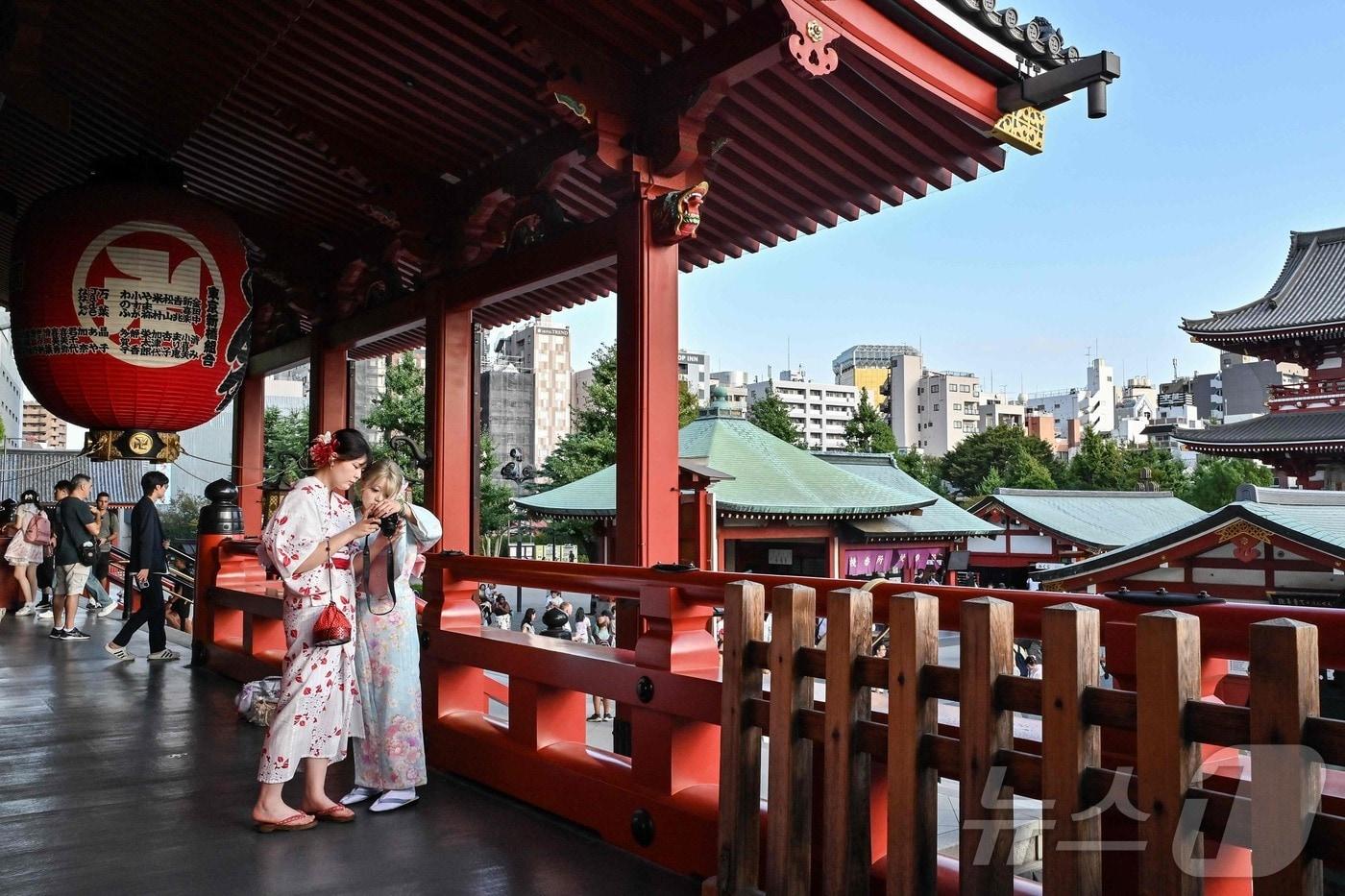 2025년 9월 16일 도쿄 중심부 아사쿠사 지역의 센소지 사원을 방문한 외국인 관광객들이 찍은 사진을 확인하고 있다. 해당 기사내용과 무관 ⓒ AFP=뉴스1 ⓒ News1 강민경 기자