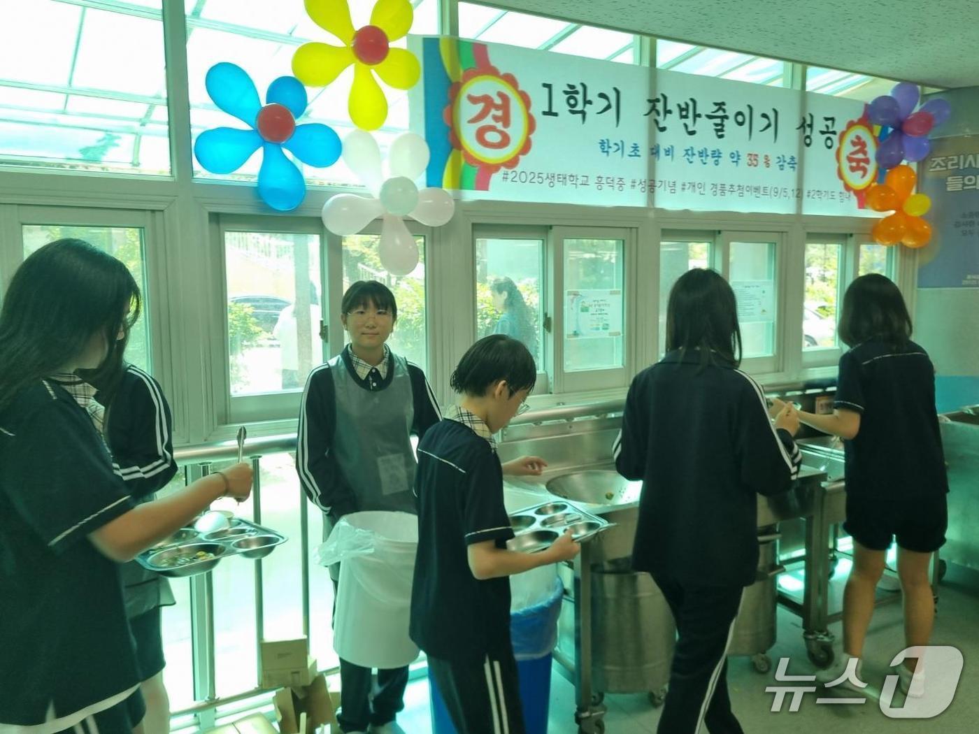 본문 이미지 - 용인 흥덕중 학생들이 &#39;잔반 줄이기 캠페인&#39;에 참여하고 있는 모습.&#40;흥덕중 제공&#41;