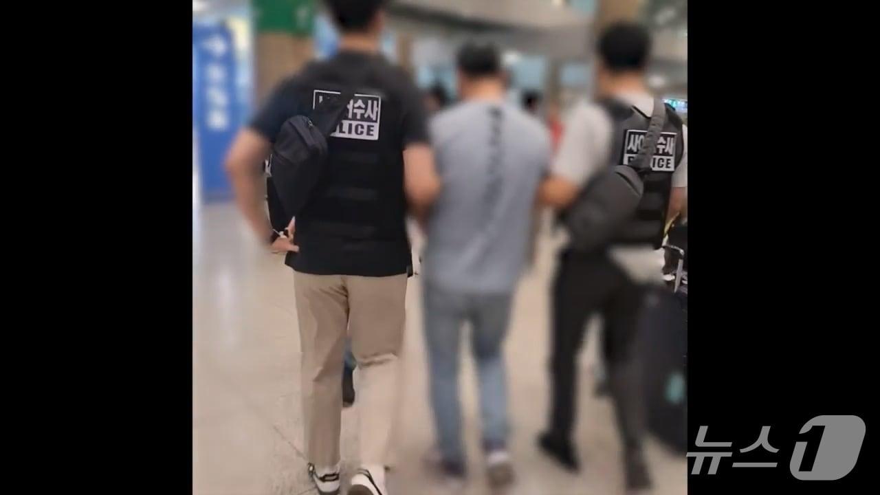 본문 이미지 - 정통망법 위반 침해 혐의로 경찰이 인천공항에서 용의자를 압송하고 있다.(경기남부경찰청 제공)