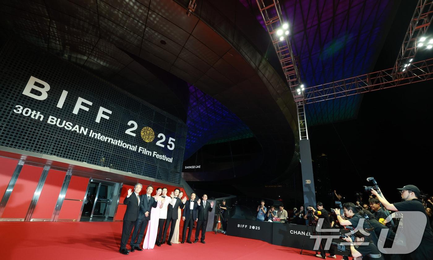 &#39;어쩔수없다&#39; 개막작 주역들이 17일 오후 부산 해운대구 영화의전당에서 열린 ‘제30회 부산국제영화제’&#40;BIFF&#41; 개막식에 참석해 관계자들과 포즈를 취하고 있다. 2025.9.17/뉴스1 ⓒ News1 권현진 기자