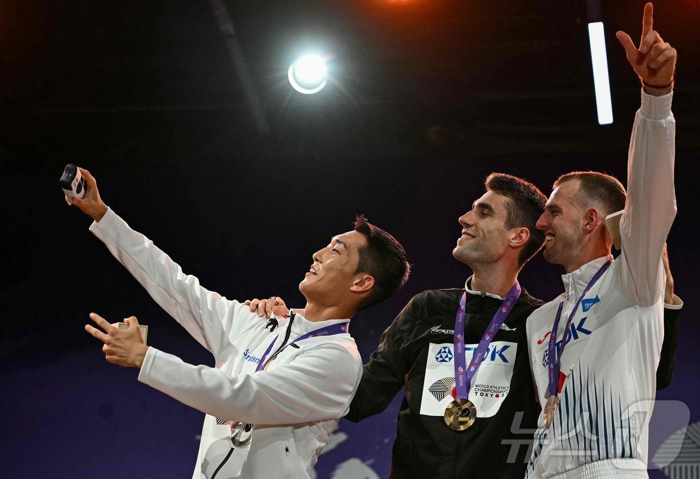 우상혁이 17일 열린 도쿄 세계 육상선수권 남자 높이뛰기 시상식에서 셀피를 찍고 있다. ⓒ AFP=뉴스1