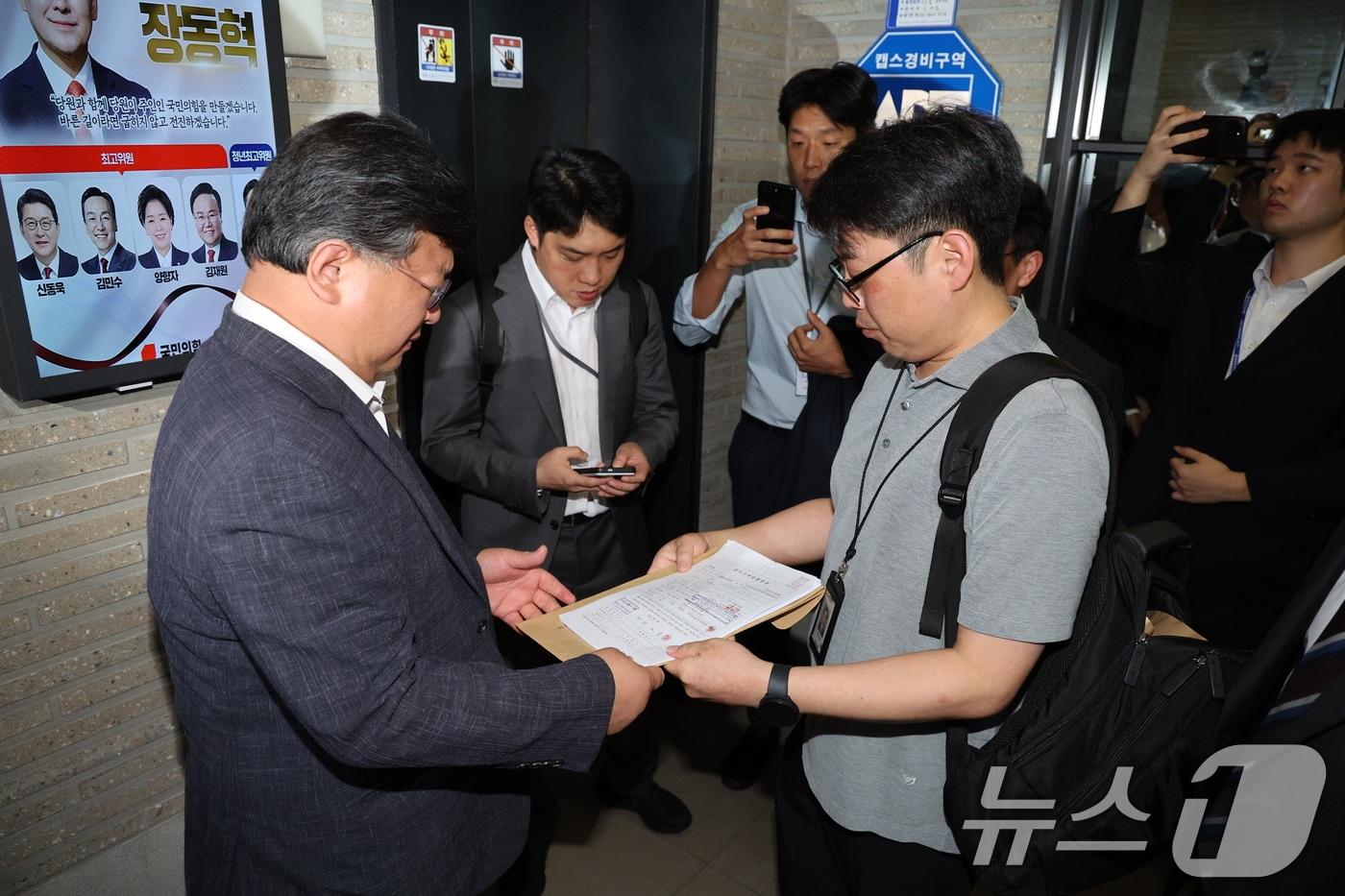 국민의힘 당원명부 압수수색에 나선 김건희특검 수사관들이 지난 18일 서울 여의도 중앙당사에서 국민의힘 변호사에게 영장을 제시하고 있다. 2025.9.18/뉴스1 ⓒ News1 신웅수 기자