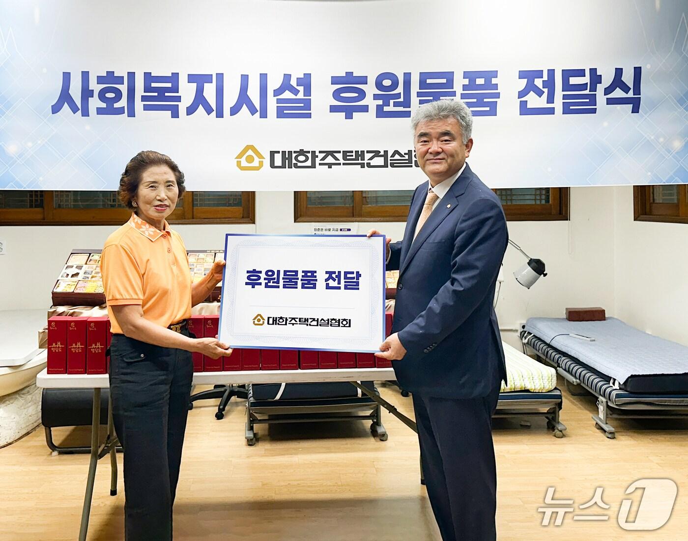 본문 이미지 - 정원주 대한주택건설협회장(오른쪽)이 구립 회현경로당 회장에게 후원 물품을 전달하고 있다./뉴스1 ⓒ News1