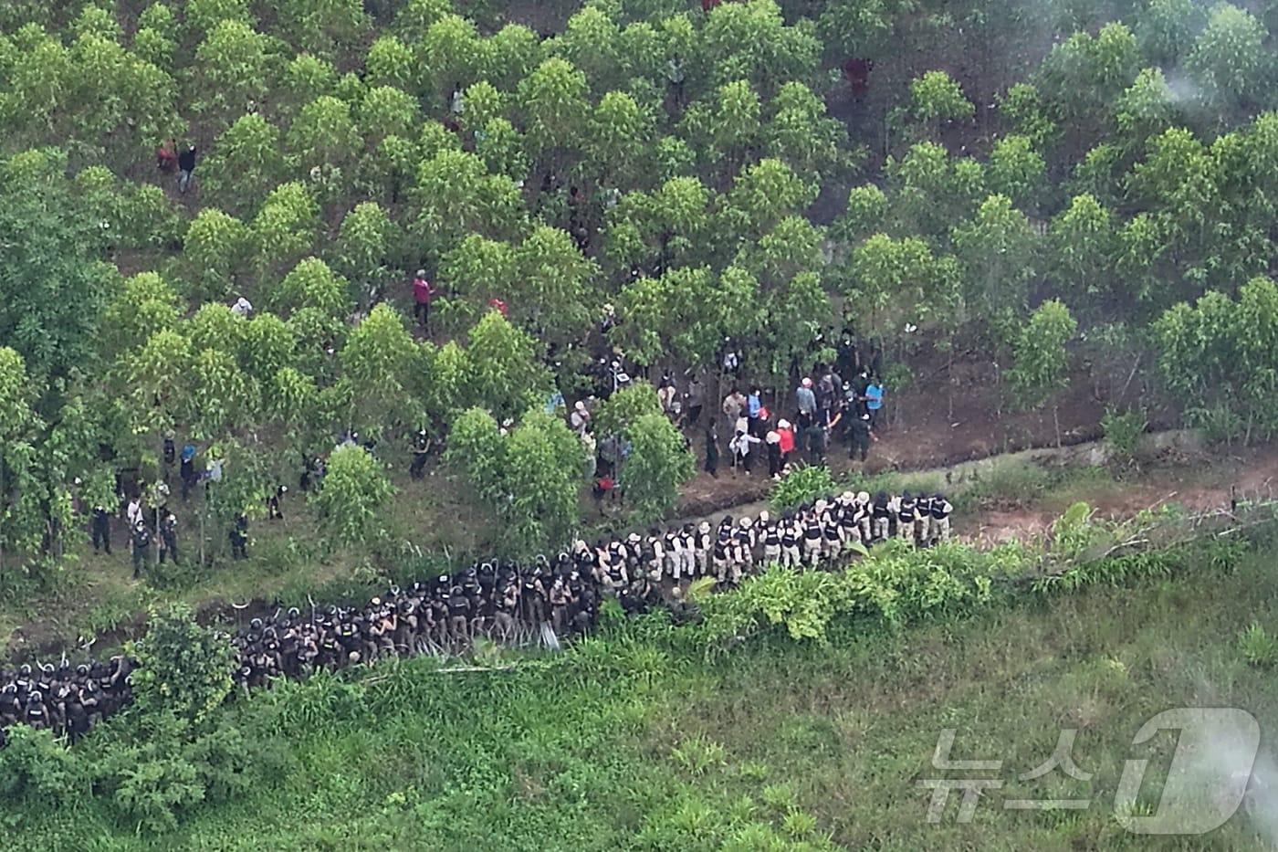 17일(현지시간) 캄보디아의 국경 분쟁 지역에 위치한 마을에서 태국 군인들과 경찰들이 캄보디아 시위대와 대치하고 있다. 2025.09.17. ⓒ 로이터=뉴스1 ⓒ News1 윤다정 기자