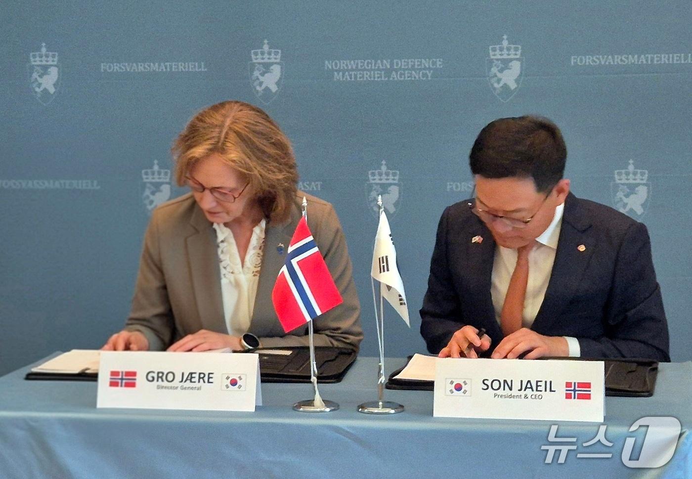 18일(현지 시간) 노르웨이 국방물자청에서 열린 노르웨이 K9 계약식에서 손재일 한화에어로스페이스 대표이사와 그로 예레 노르웨이 국방물자청 청장이 계약서에 서명하고 있다(한화에어로 제공)