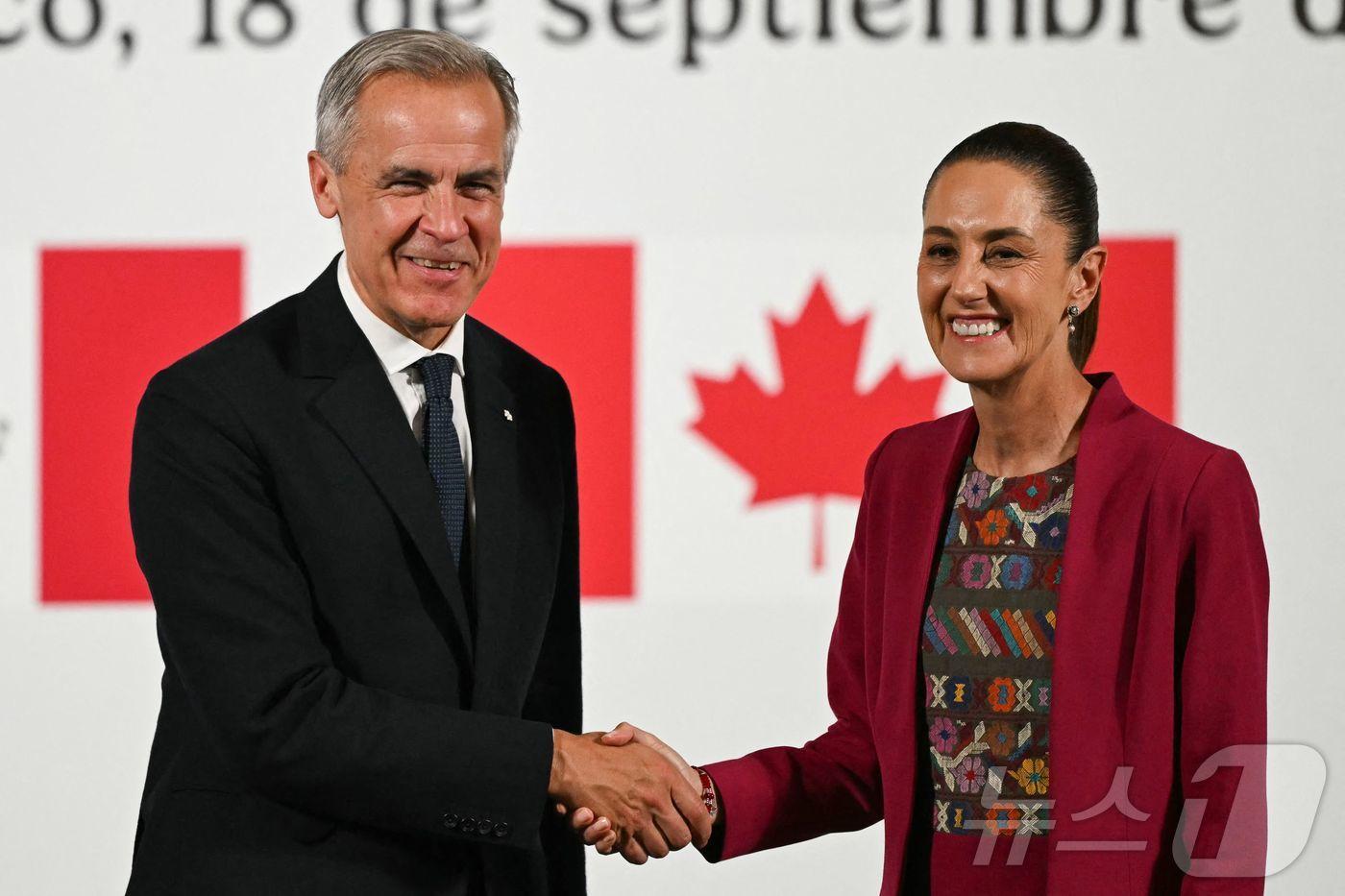 18일(현지시간) 멕시코시티의 국립궁전에서 마크 카니 캐나다 총리(왼쪽)와 클라우디아 셰인바움 멕시코 대통령(오른쪽)이 공동 기자회견을 마치고 악수를 하고 있다. 2025.9.18 ⓒ AFP=뉴스1