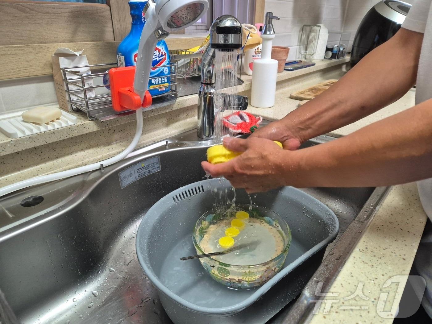 본문 이미지 - 강원 강릉지역 저수조 용량 100톤 이상 아파트 113곳에 대한 시간제 제한급수가 풀린 19일 저녁 강릉 회산동의 한 아파트 주민이 수돗물을 이용해 설거지를 하고 있다. 2025.9.19/뉴스1 ⓒ News1 윤왕근 기자