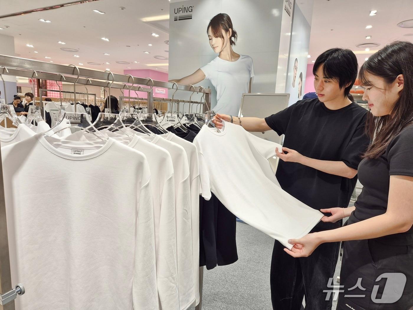 본문 이미지 - 롯데백화점 부산본점을 방문한 고객들이 티셔츠 브랜드 유핑 팝업 매장을 둘러보고 있다.(롯데백화점 제공. 재판매 및 DB 금지)