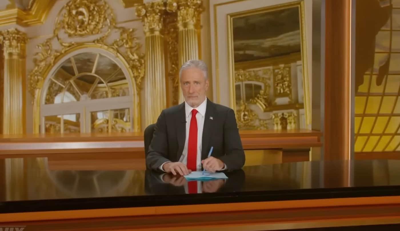 ABC의 &#39;데일리 쇼&#39; 호스트 존 스튜어트가 도널드 트럼프 대통령의 마러라고 별장을 연상시키는 금색 세트에서 트럼프 대통령이 즐겨 입는 빨간색 넥타이를 매고 정장을 입으면서 행정명령에 서명하는 흉내를 내고 있다. &#40;사진=데일리쇼 유튜브 갈무리&#41;