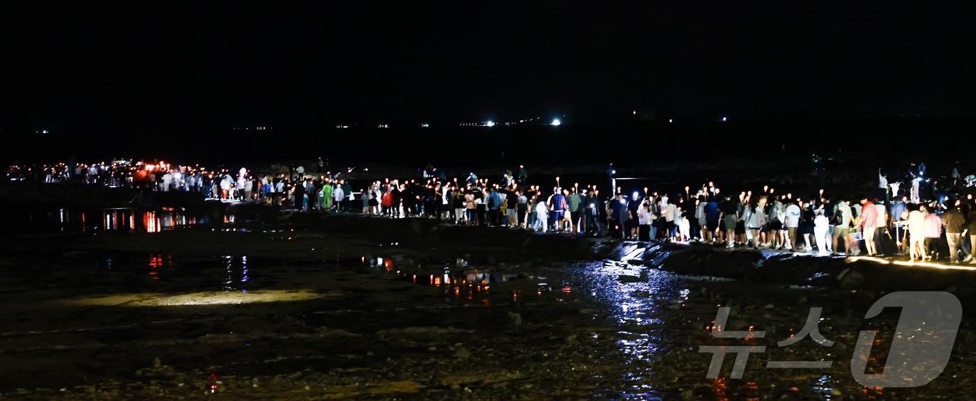 LED 횃불을 든 시민들이 지난달 20일 오후  '25회 무창포 신비의 바닷길 축제' 현장에서 대행진을 펼치고 있다. (보령시 제공, 재판매 및 DB금지)/뉴스1
