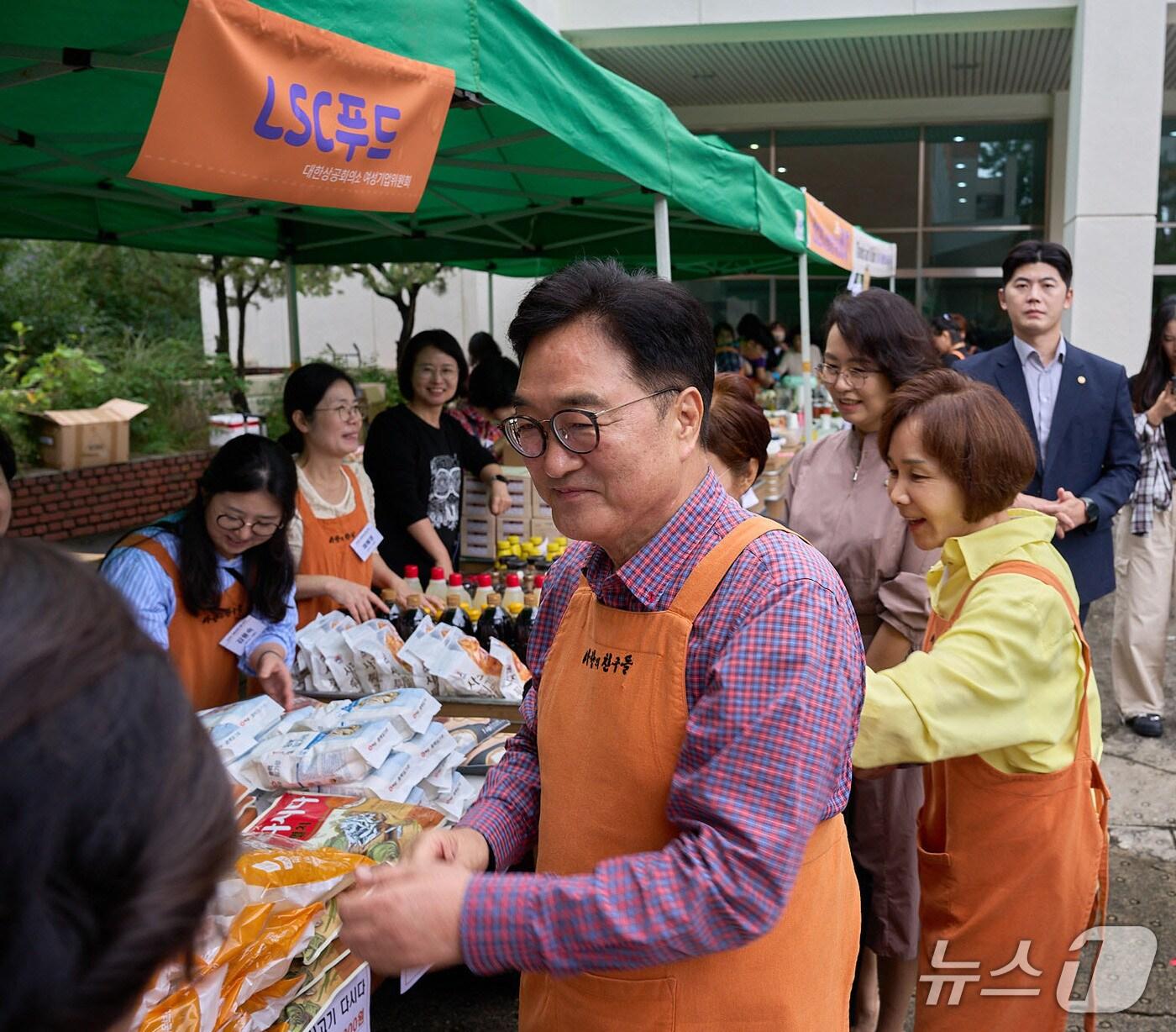 본문 이미지 - 우원식 국회의장과 정기옥 대한상의 여성기업위원회 위원장이 사랑의 친구들 바자회에 참석해 자원봉사를 하고 있다(대한상의 제공)