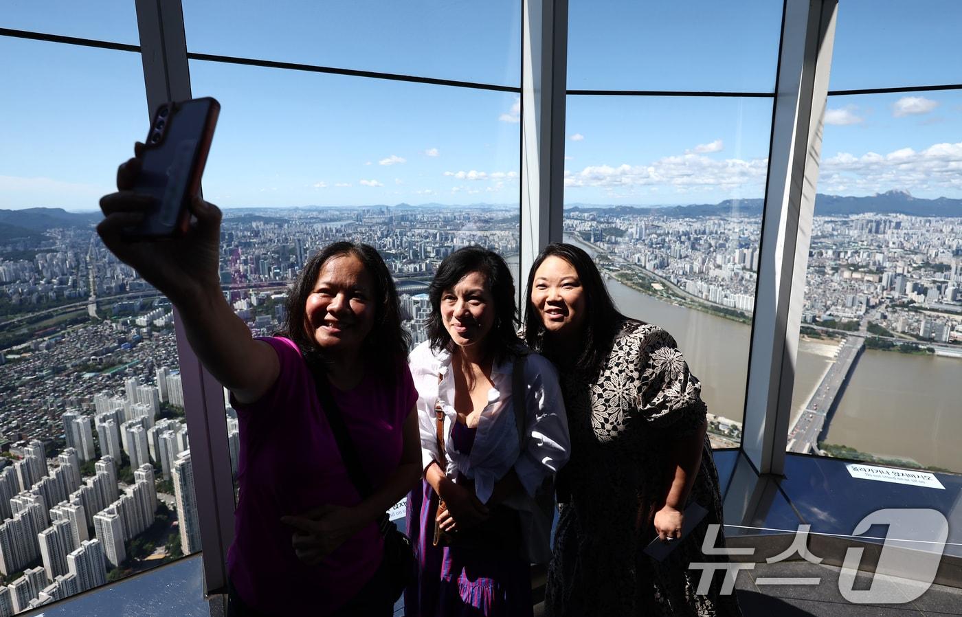 완연한 가을 날씨를 보인 21일 서울 송파구 롯데월드 서울스카이 전망대에서 관광객들이 맑은 하늘을 배경으로 사진을 찍고 있다. 2025.9.21/뉴스1 ⓒ News1 김민지 기자