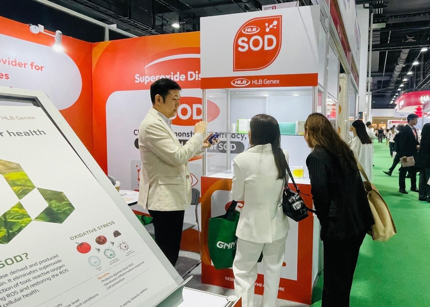 본문 이미지 -  HLB제넥스 관계자가 '비타푸드 아시아 2025'에서 부스 방문객에게 SOD에 대해 소개하고 있다. (HLB제넥스 제공)