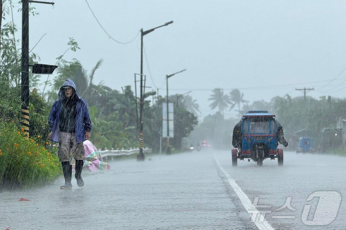 22일 필리핀 카가얀 주 랄로 마을에서 한 남성이 초강력 태풍 라가사의 영향으로 쏟아지는 폭우 속 도로를 걷고 있다. 이날 북부 필리핀과 남부 대만을 강타한 라가사의 폭우와 강풍으로 수백 가구가 학교와 대피소로 긴급 대피했다.2025.09.22.ⓒ AFP=뉴스1