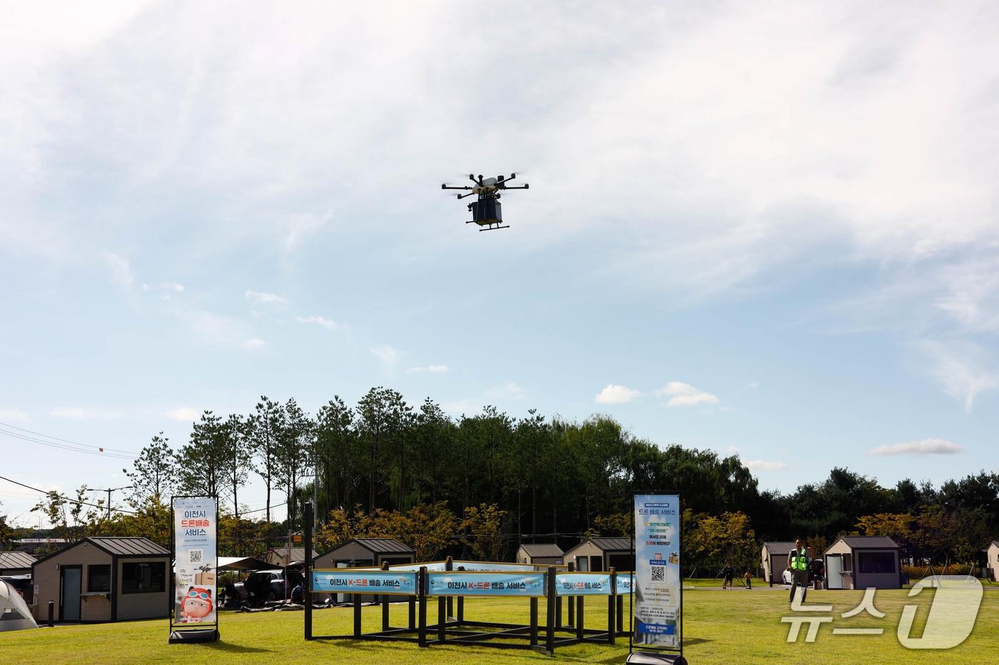 이천시가 지난 21일 복하천 제3수변공원 캠핑장에서 진행한 드론 배송 시연회에서 드론이 배달점에 물건을 투하 하고 있는 모습.&#40;이천시 제공&#41;