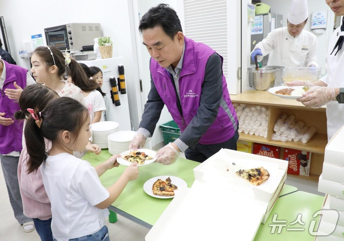 강원랜드가 22일 강원 정선군 별빛달빛 지역아동센터에서  어린이들을 대상으로 &#39;셰프와 함께하는 행복한 음식 나눔&#39; 봉사에 나섰다.  최철규 강원랜드 대표이사 직무대행이 아이들에게 피자를 주고 있는 모습. &#40;강원랜드 제공. 재판매 및 DB금지&#41; 2025.9.22/뉴스1