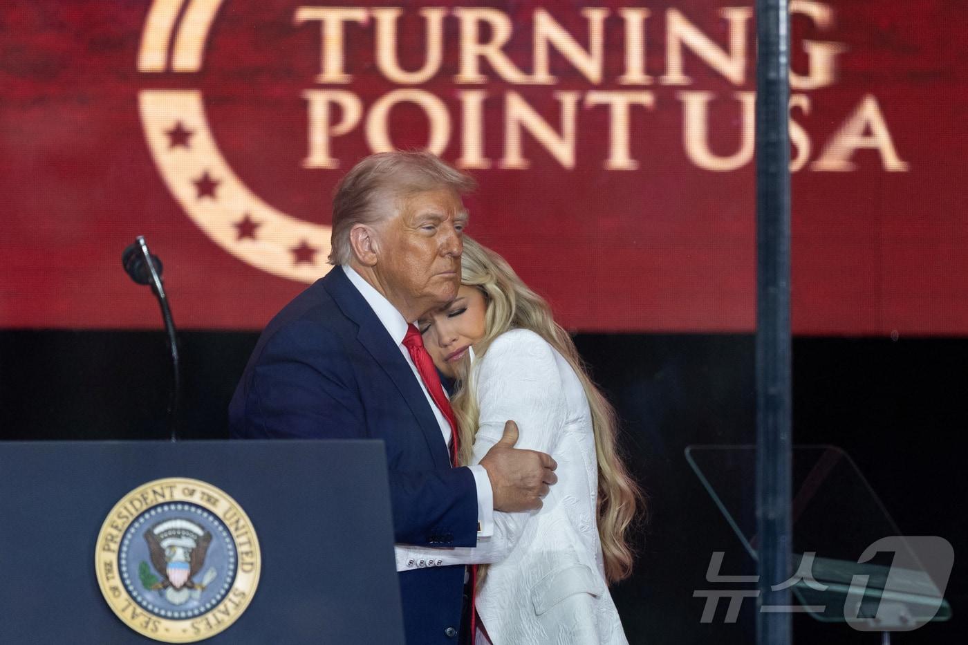 21일(현지시간) 도널드 트럼프 미국 대통령이 애리조나주 글렌데일에서 열린 보수 논객 찰리 커크를 기리는 추모식에서 커크의 아내인 에리카 커크를 포옹하고 있다. 2025.09.21 ⓒ 로이터=뉴스1 ⓒ News1 김지완 기자