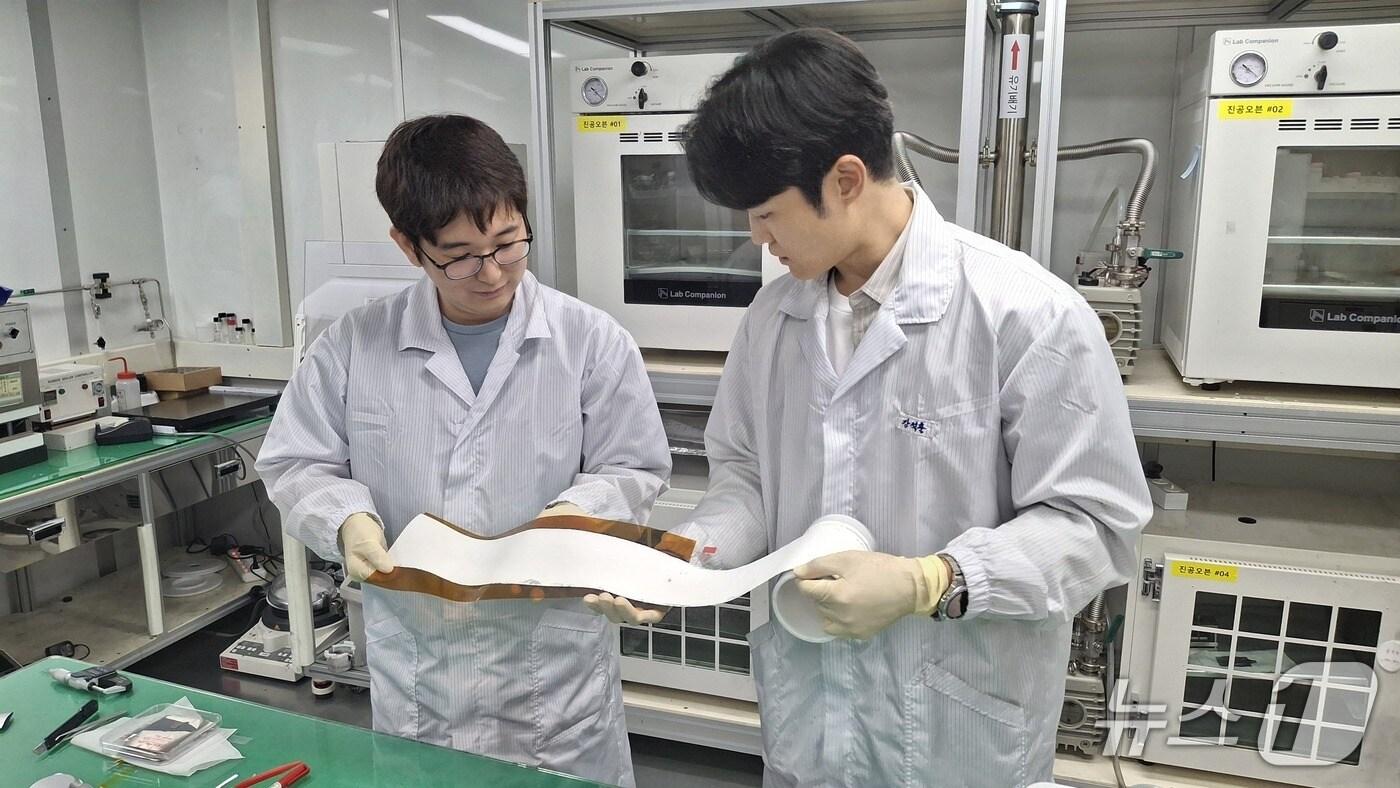 롤 형태로 제조된 대면적 고체전해질막의 전체 품질과 외관 상태를 점검하는 ETRI 연구진&#40;ETRI 제공&#41; /뉴스1