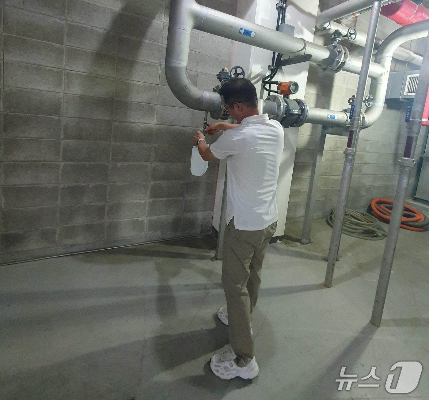 본문 이미지 - 한강청 환경감시단이 지난 7월 23일 경기 용인시의 한 대형 상업시설의 오수처리시설 최종 방류구에서 방류수 수질 검사용 시료를 채취하고 있는 모습.&#40;한강청 제공&#41;