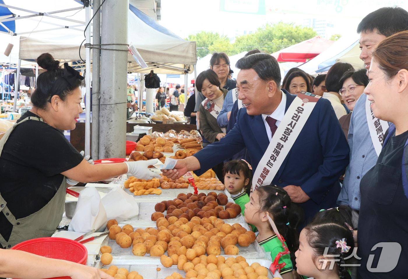 우리동네 전통시장 장보go(고) 행사가 23일 울주군 남창옹기종기시장에서 열린 가운데 김두겸 울산시장이 온누리상품권으로 도너츠를 구매하고 있다. (울산시 제공. 재판매 및 DB 금지) /뉴스1