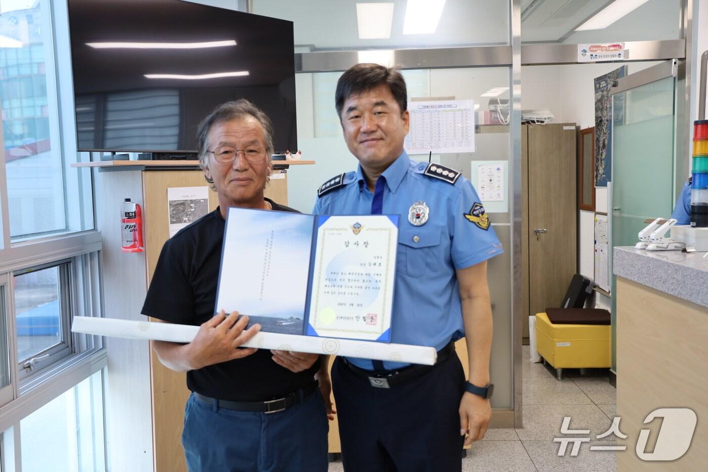 안철준 울산해양경찰서장(오른쪽)이 23일 기장파출소를 찾아 기장 동백항 김태호 선장(왼쪽)에게 감사장을 수여하고 사진을 찍고 있다.(울산해경 제공. 재판매 및 DB금지)/뉴스1