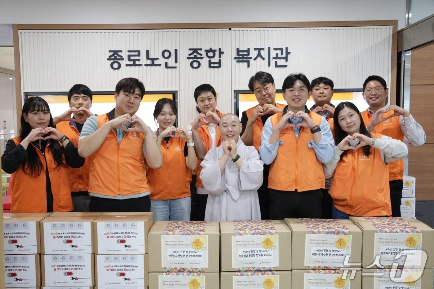 본문 이미지 - ㈜한화 글로벌부문 임직원 봉사단이 종로노인종합복지관장 정관 스님과 기념촬영을 하고 있다(한화 제공)