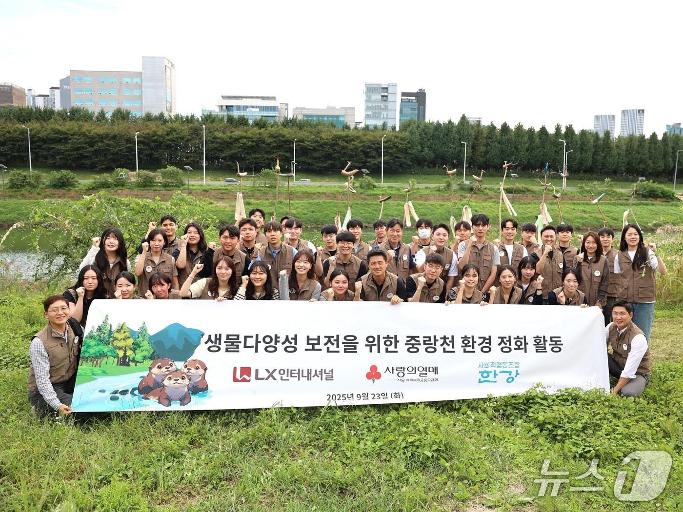 본문 이미지 - 서울 중랑천 일대 생물다양성 보전 활동에 나선 LX인터내셔널 임직원들이 기념 촬영을 하고 있다. &#40;사진제공 = LX인터내셔널&#41; 