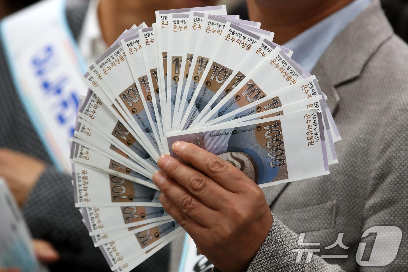 관계자들이 전통시장 활성화를 위해 구매한 상품권을 펼쳐 보이고 있다. 2025.9.24/뉴스1 ⓒ News1 공정식 기자