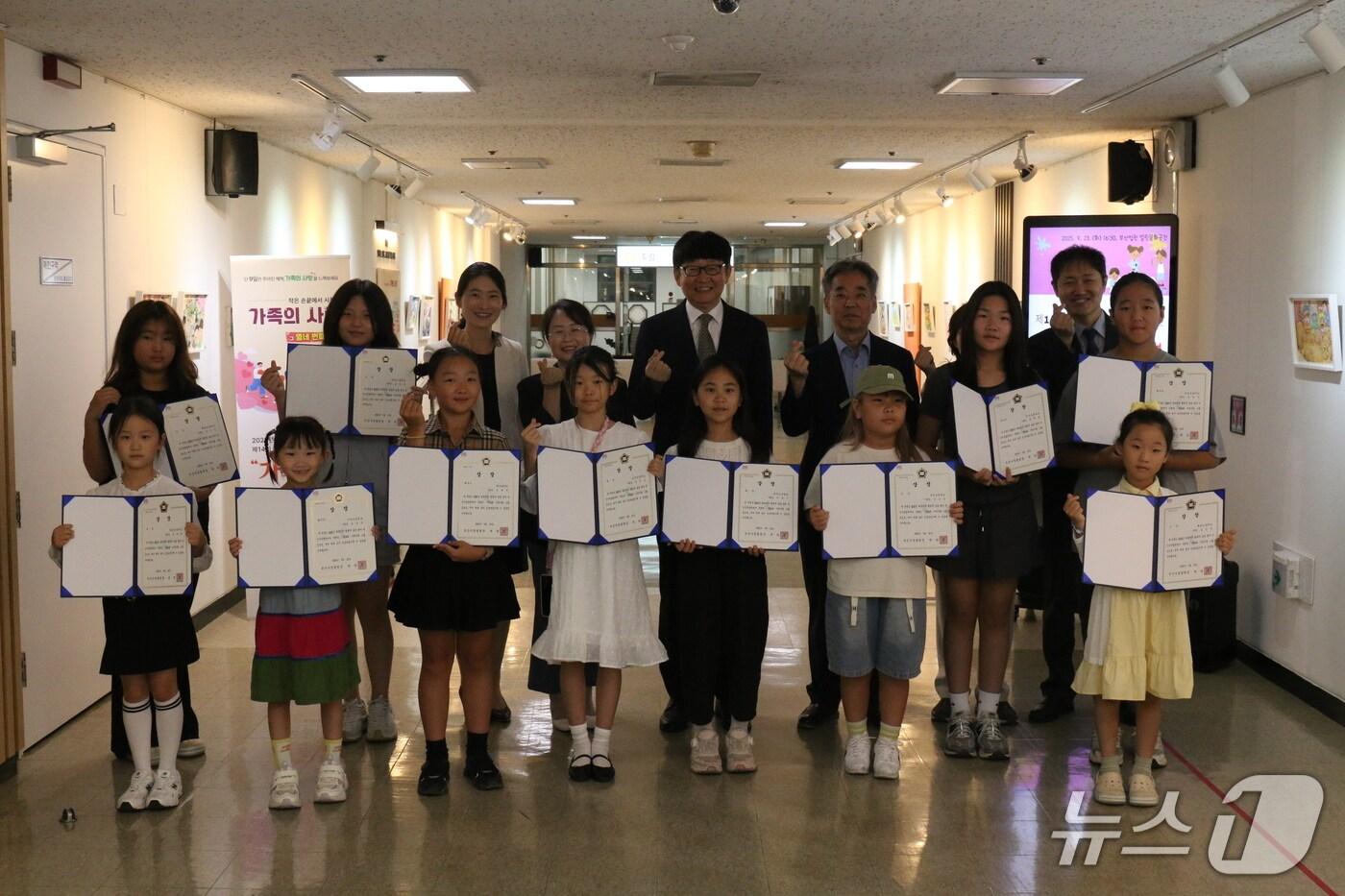 부산가정법원 관계자들과 가족사랑 그림공모전에 참가한 어린이들이 상을 받은 뒤 기념사진을 찍고 있다.(부산가정법원 제공. 재판매 및 DB 금지)