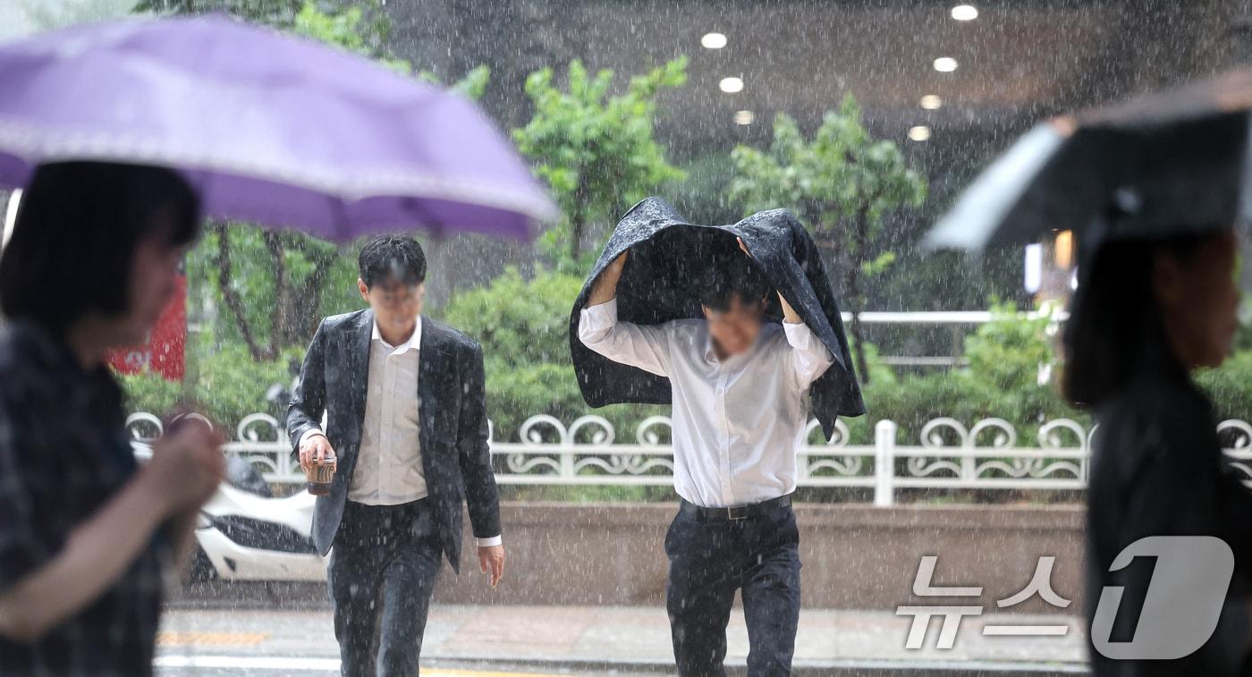 전국적으로 가을비가 내리는 24일 서울 종로구 한 거리에서 우산이 없는 시민들이 겉옷으로 비를 막으며 발걸음을 제촉하고 있다. 2025.9.24/뉴스1 ⓒ News1 이호윤 기자