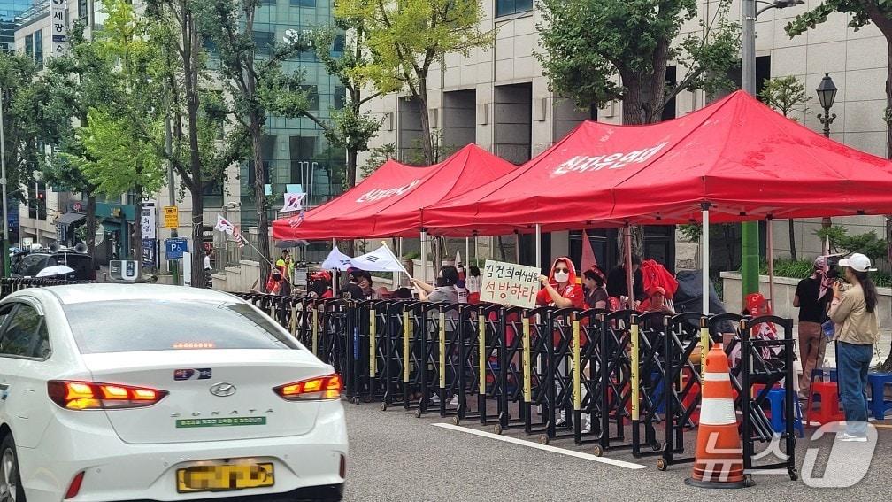 본문 이미지 - 24일 서울 서초구 서울중앙지법 앞에서 열린 보수단체 신자유연대의 집회에서 한 참가자가 '김건희 여사님을 석방하라'는 피켓을 들고 있다.