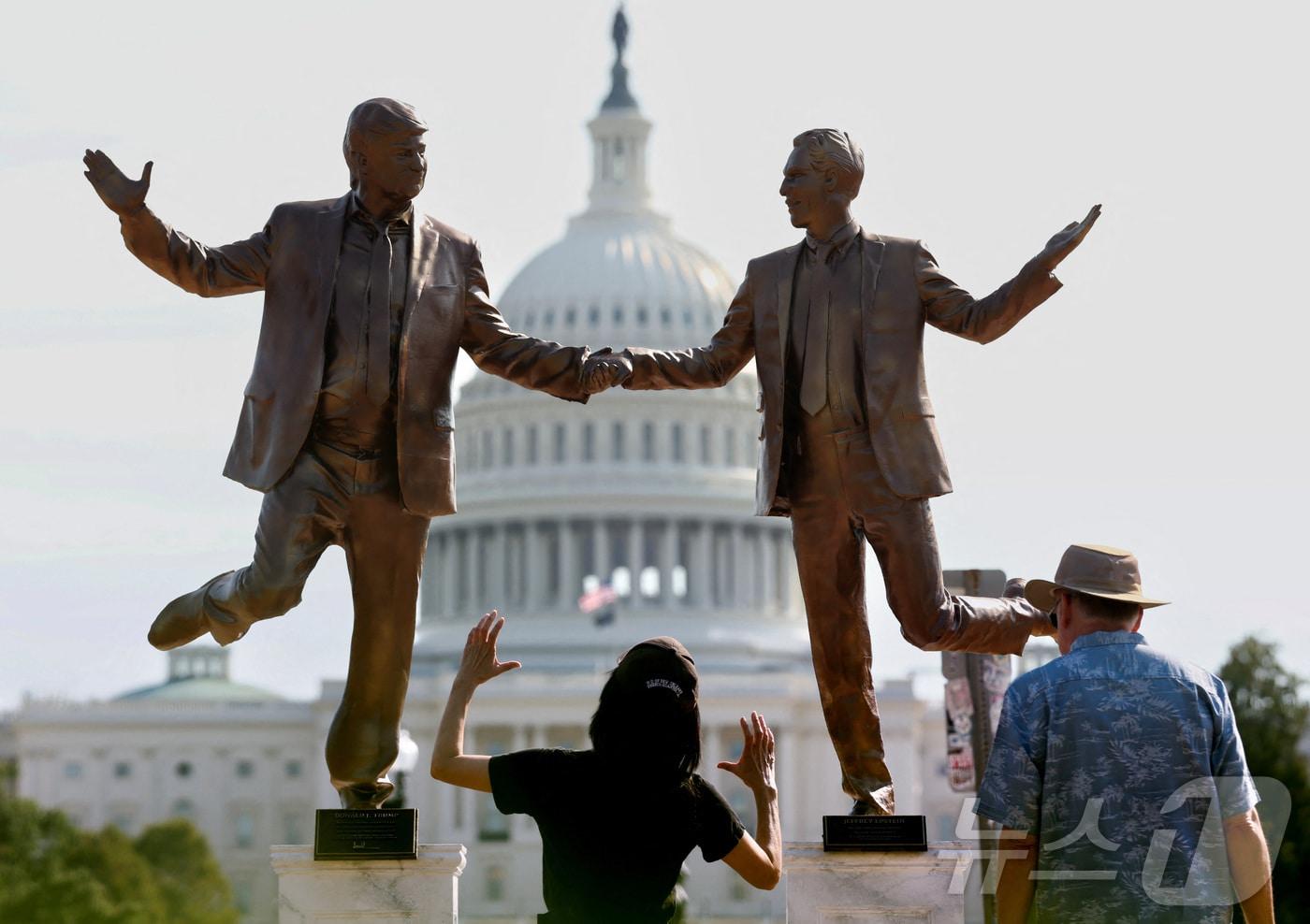 23일&#40;현지시간&#41; 미국 워싱턴DC 연방의회 의사당 앞 내셔널 몰에 설치된 동상 앞에서 방문객들이 도널드 트럼프 미국 대통령과 제프리 엡스타인의 모습을 묘사한 조각상을 올려다보고 있다. 2025.09.23. ⓒ 로이터=뉴스1 ⓒ News1 윤다정 기자