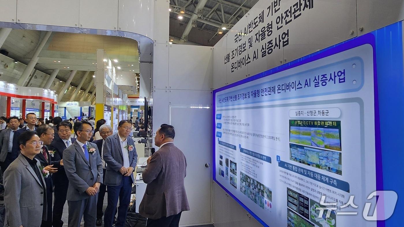 최은수 인텔리빅스 대표&#40;오른쪽&#41;가 부스를 찾은 김명주 경상남도 경제부지사&#40;왼쪽에서 두번째&#41;와 관계자들에게 전시 설루션을 설명하고 있다&#40;인텔리빅스 제공&#41;