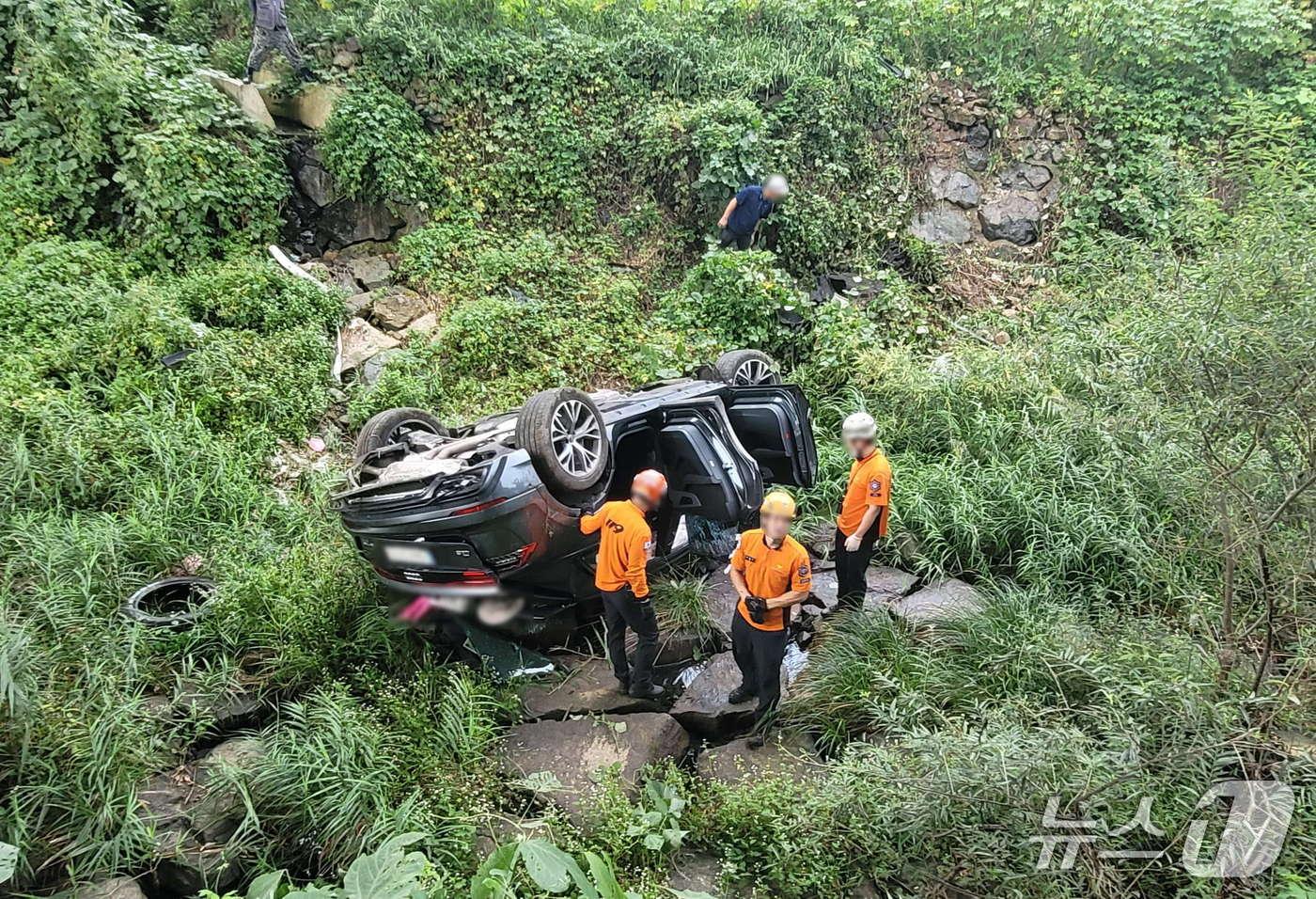 부산 기장군 홍연폭포 부근에 추락한 SUV차량.(부산경찰청 제공. 재판매 및 DB금지)