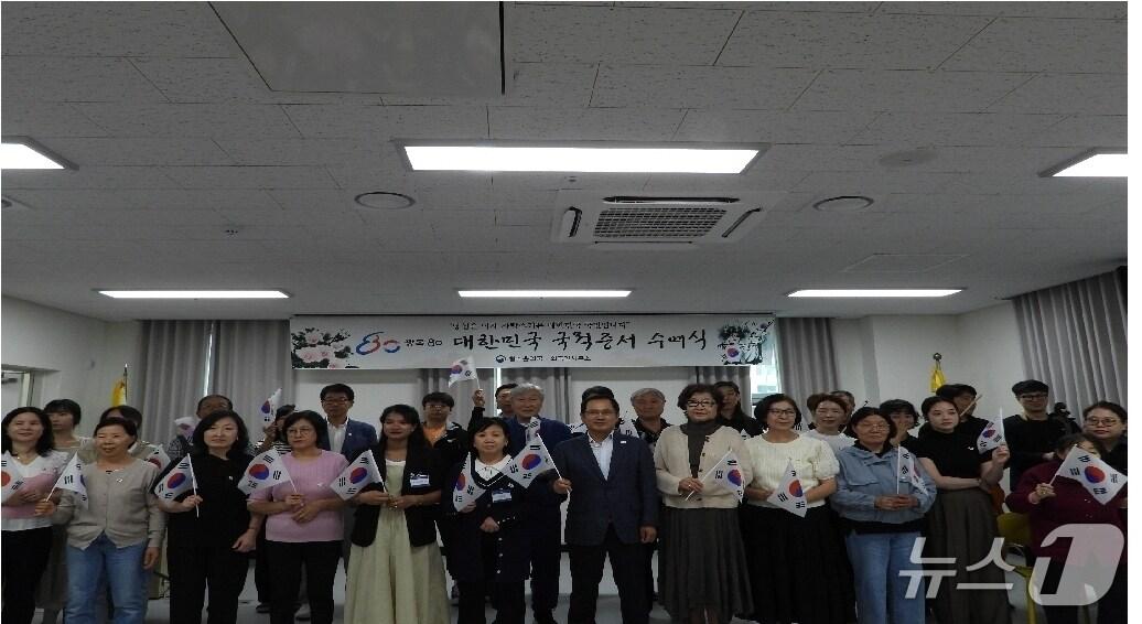 본문 이미지 - 법무부 청주출입국·외국인사무소 관계자 등이 25일 사무소 대회의실에서 열린 '국적증서 수여식'을 마치고 기념 촬영을 하고 있다.(법무부 청주출입국·외국인사무소 제공. 재판매 및 DB금지)/뉴스1