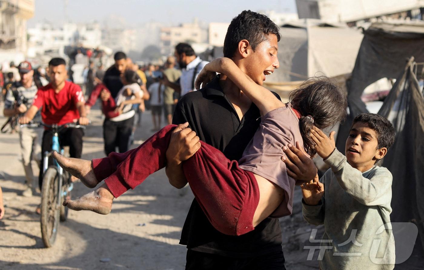 7일&#40;현지시간&#41; 가자시티의 알자지라 텐트에 대한 이스라엘 공습 직후 한 팔레스타인 소년이 부상당한 소녀를 안아 들고 있다. 2025.09.07. ⓒ 로이터=뉴스1 ⓒ News1 윤다정 기자