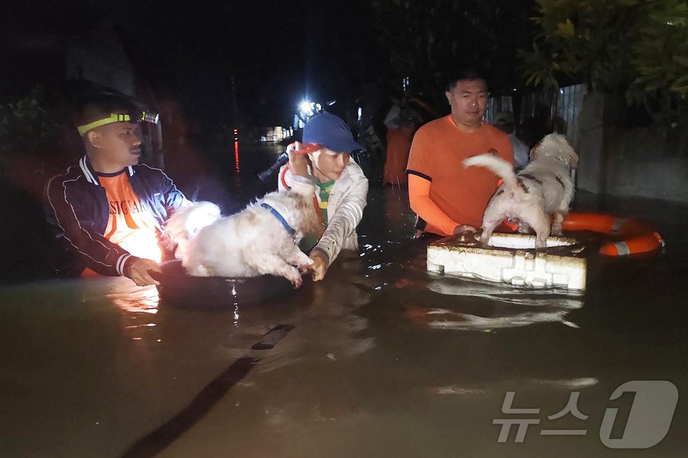 필리핀 중부에서 열대성 폭풍으로 홍수가 발생하자 26일 해양경비대가 출동해 해안가 집에 있던 반려견들을 구출하고 있다. 2025.9.26 ⓒ AFP=뉴스1 ⓒ News1 강민경 기자