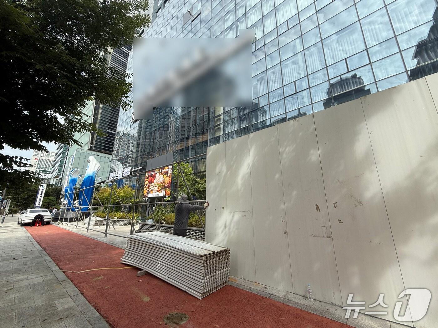 본문 이미지 - 22일 광주 서구 상무지구에 위치한 호텔·예식장 건물 주변에 가벽이 설치되는 모습. 2025.9.22.뉴스1 /김태성 기자